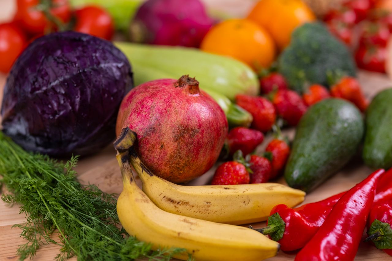 Home A variety of fresh fruits and vegetables arranged beautifully on a wooden table, showcasing natural nutrition.